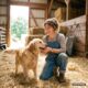 Tierpflegerin lacht mit einem Golden Retriever im Stall, KI-generiertes Bild